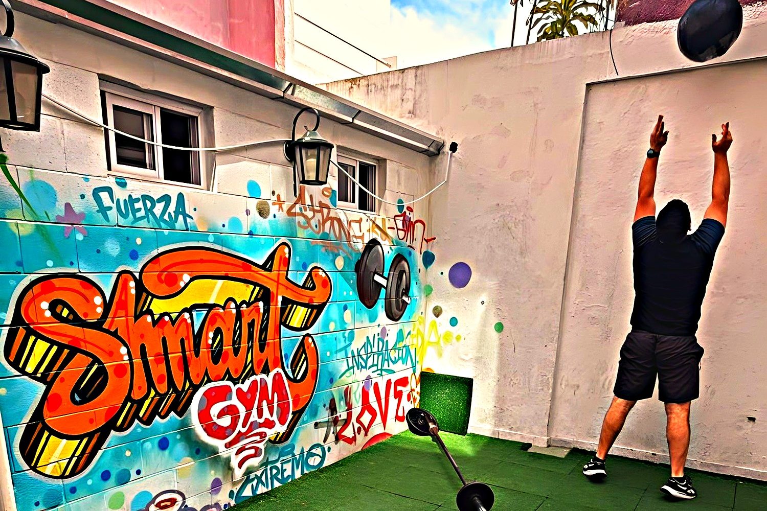 Patio de entrenamiento al aire libre con césped sintético y el mural de SMART