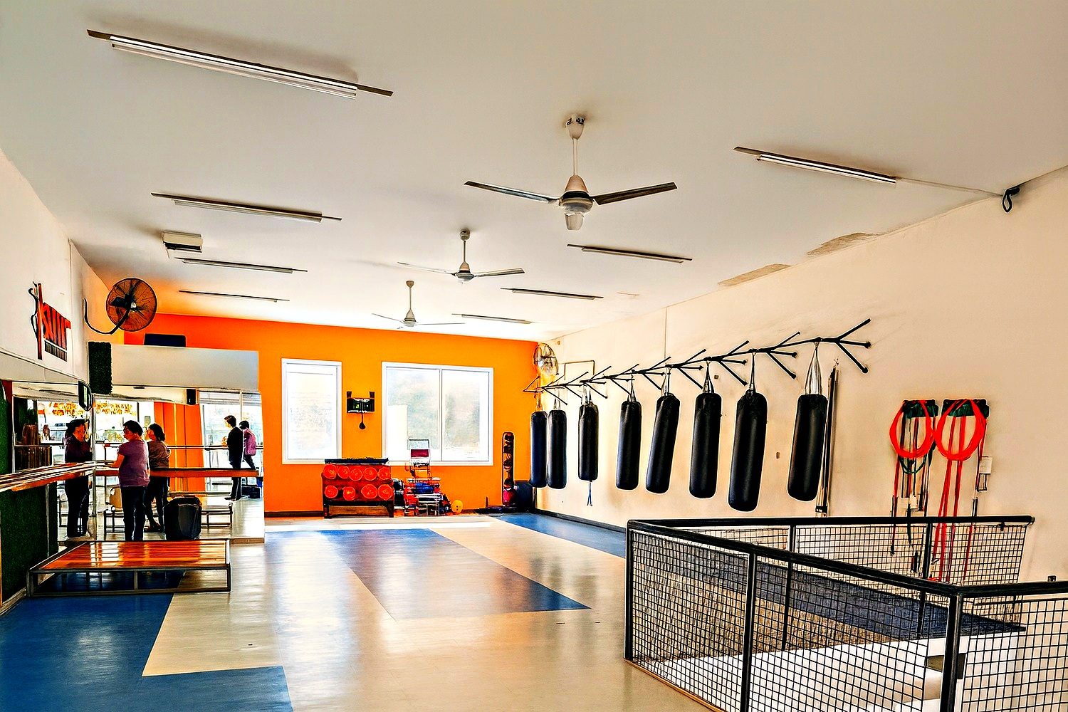 Sala amplia con espejos y equipamiento contra la pared